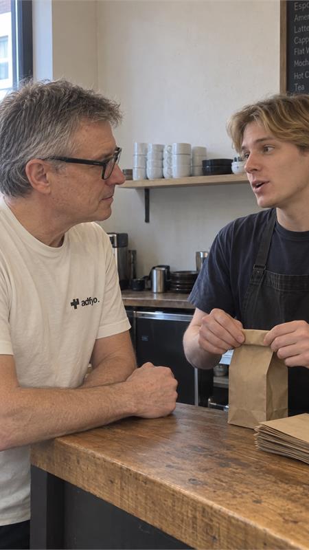 An Adfyo colleague discussing a cafe business with its barista