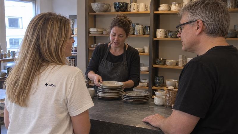 The Adfyo crew discussing a location inside a small ceramics shop