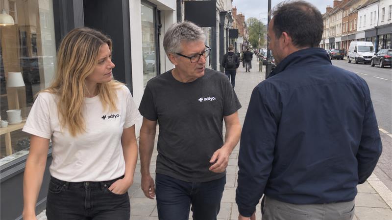 Two Adfyo colleagues continuing a conversation with a client outside his high-street shop