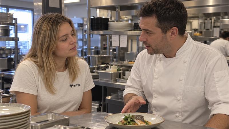 An Adfyo colleague discussing a dish with a working chef