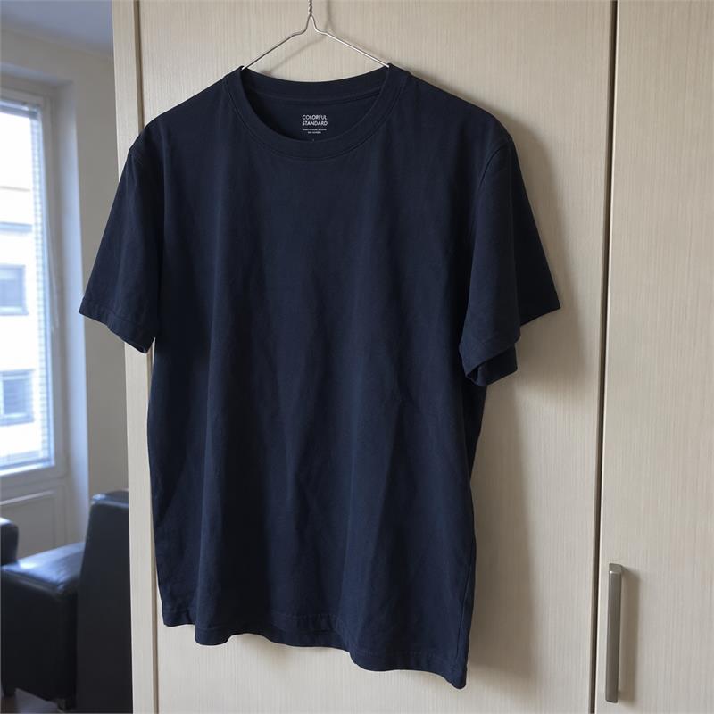 A navy Colorful Standard Classic Organic Tee on a wire hanger