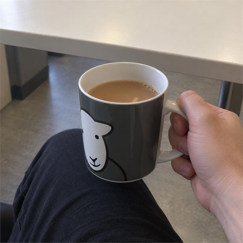 A glossy white Herdy Hello Ewe china mug during an ordinary tea break