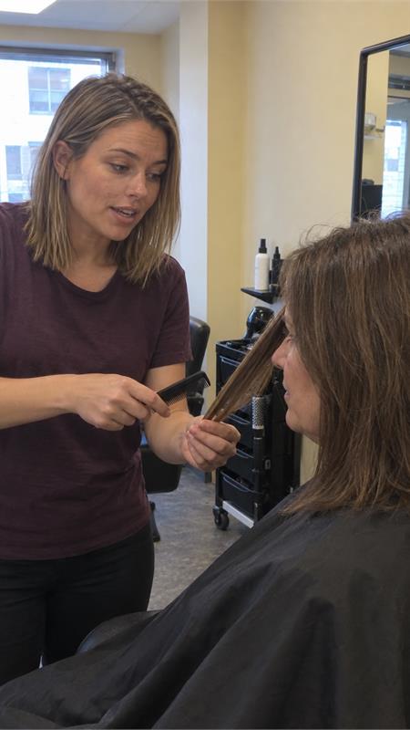 A hairdresser discussing a haircut with a customer